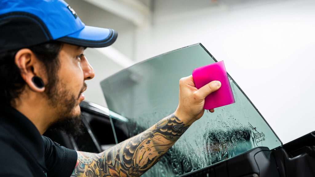 Using a squeegee to install ceramic tint