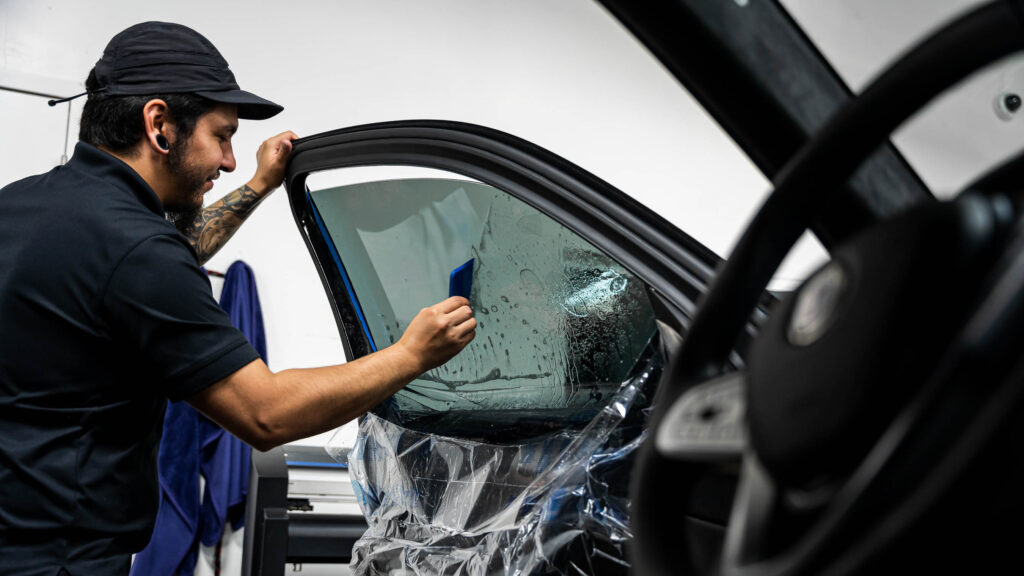 Using a squeegee to install window tint