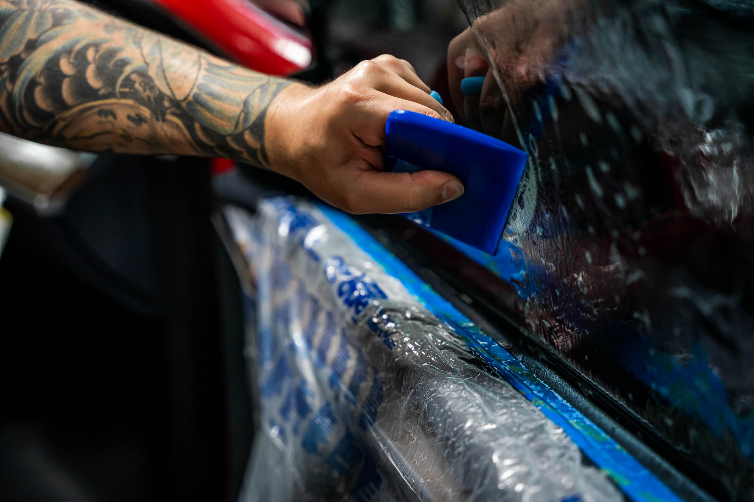 Installing tint with a squeegee up close