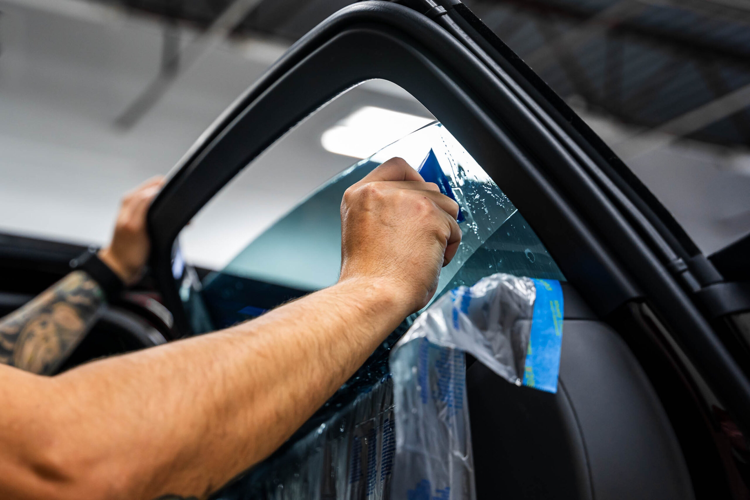 Using a squeegee to install tint on passenger front window
